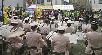 県警音楽隊の演奏。いっずんや防犯・交通のキャラクターが登場した＝区提供