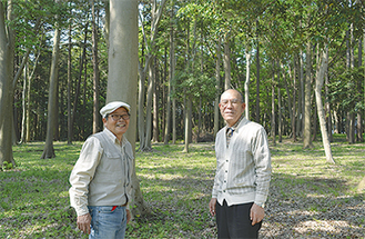再生した森に立つ天野会長（右）と酒井副会長