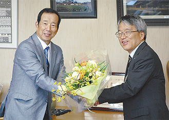 下村区長から花束を受け取る鈴木会長（左）