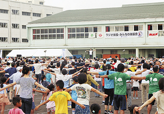 中和田中グラウンドに整列してラジオ体操する参加者たち