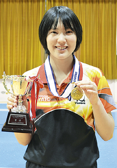 優勝トロフィーとメダルを掲げる笹尾さん