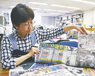 カッターで一部を切り取られた新聞を見せる西川さん