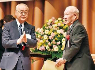 受賞者を称える市交通安全協会の板橋悟会長（左）