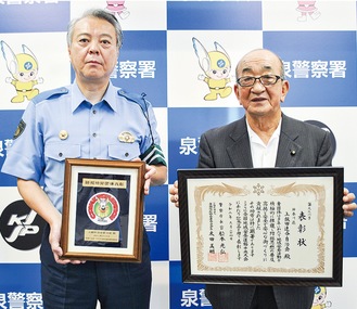 泉警察署の柴田直樹署長（左）に表彰を報告する馬場会長（右）＝9月28日撮影