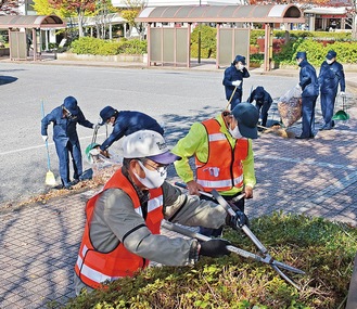 ツツジの花壇を剪定する住民と、枯れ葉を清掃する相鉄駅員ら