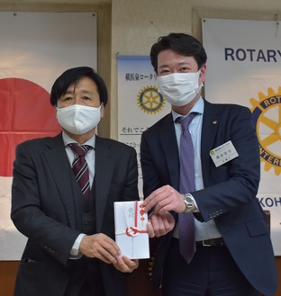 寄付金を受け取る共働舎の萩原施設長と泉RCの飯田会長