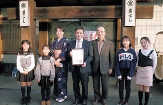 石山代表(中央)と馬場会長、和泉小学校の児童ら
