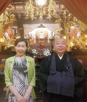 本堂の前に立つ小谷さん（左）と梅田住職