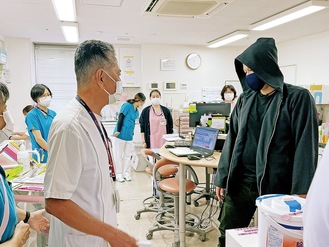 不審者を落ち着かせようとする飯澤病院長（左）