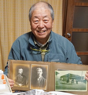 曾祖父の鑊雄さん（中央）の写真を持つ慎司さん