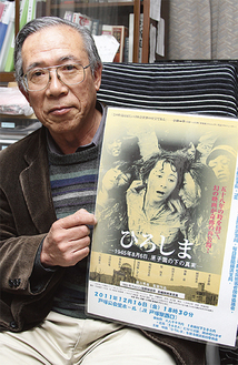 作品のポスターを手にする主催者代表の竹岡さん