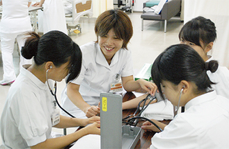 看護師（中央）の指導で血圧測定も体験