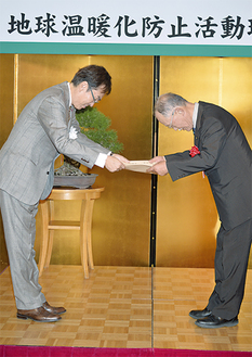 石原伸晃大臣から表彰を受ける田中会長（右）