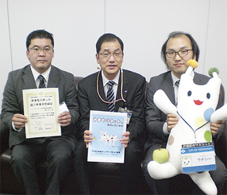 授与式で葛西区長（当時・写真中央）から登録証を手渡された中村さん（左）、前田さん