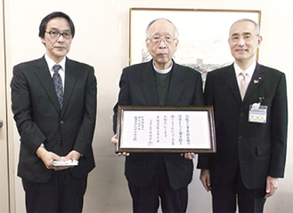 伝達式に臨んだ今井理事長（中央）と水野施設長（左）。右は岡田健康福祉局長