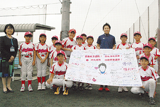 応援旗を手に笑顔の山田選手と児童たち、左は田雑由紀乃戸塚区長