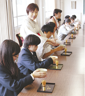 茶碗を手に作法を学ぶ生徒