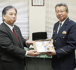 グッズを受け取る小島伸治署長（右）と東京セキスイハイムの奥田所長