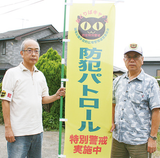 「おどりばキャッツ」のロゴが入った旗を持つ林会長（右）と浜野俊一副会長