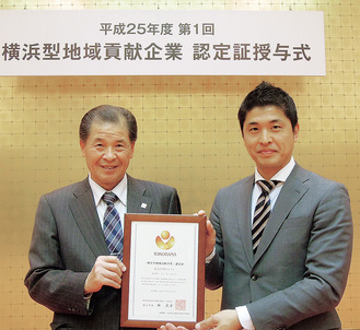 2013年、横浜型地域貢献企業最上位認定の認定授与式で。川口健治代表取締役社長（左）と川口大治常務取締役（右）