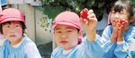 笑顔でイチゴを手にする園児