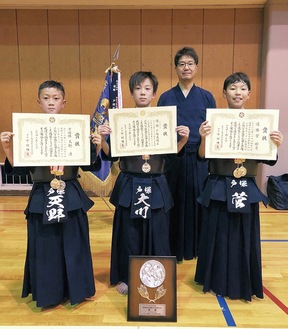 県予選の賞状を持つ小学生の部のメンバーと槌田さん