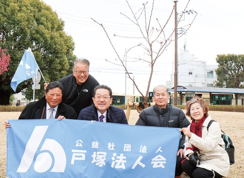 桜の前に並ぶ会員