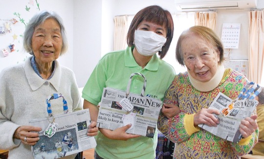 エコバッグを持ち笑顔の利用者と石井さん（中央）