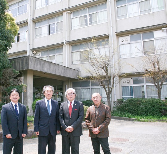 舞岡高校の前に立つ宇田校長（左から2人目）と学校関係者と同窓会メンバー