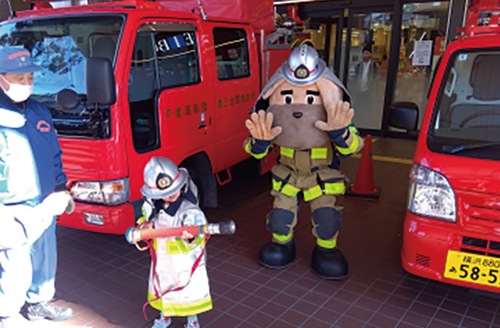 防火服試着体験をする子ども