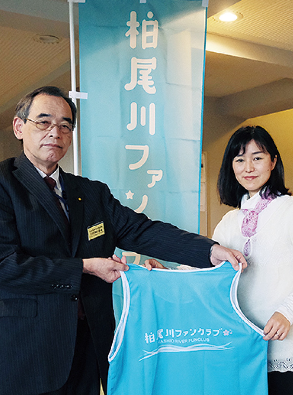 川畑会長から寄贈品を受け取る丸山代表（右）