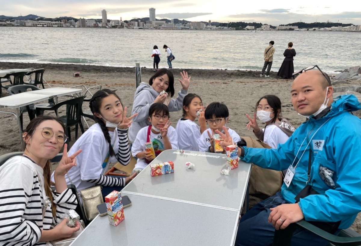 海をバックにする参加者(同)