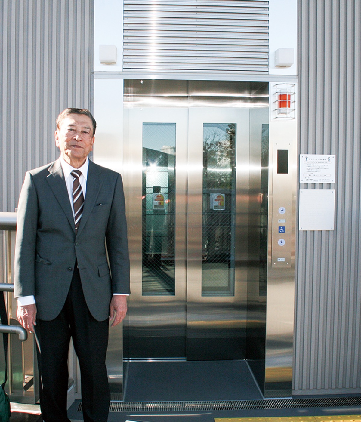 エレベーターの前に立つ齋藤さん