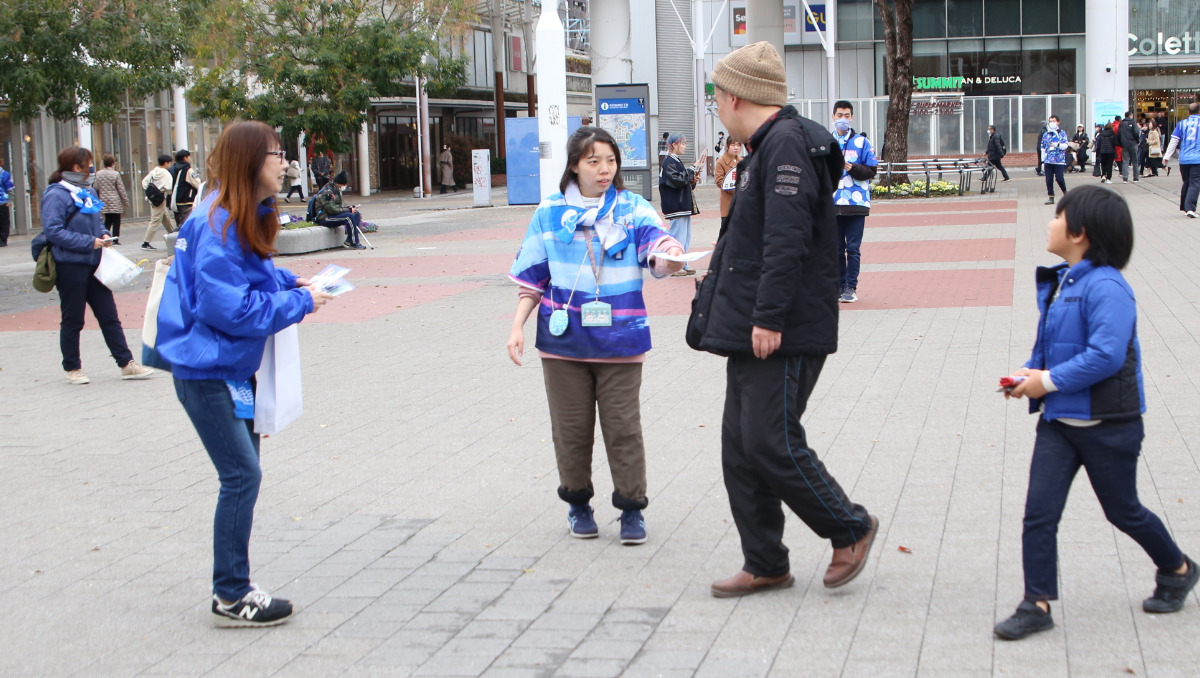 駅前でチラシを配布する参加者
