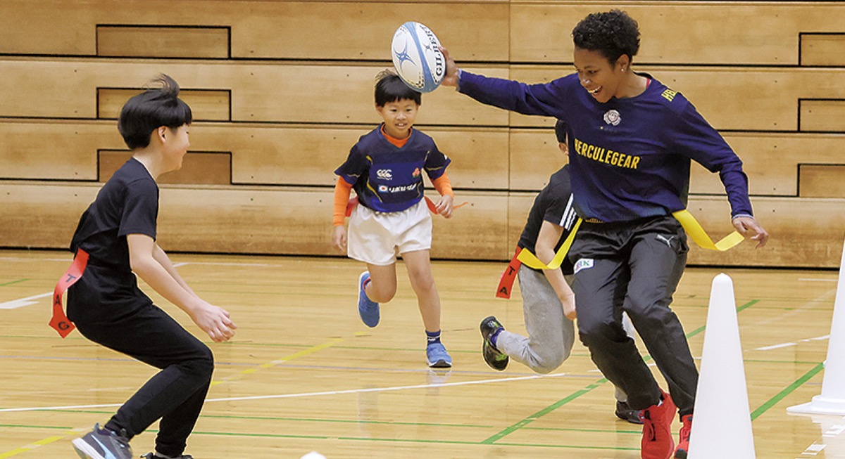 選手とタグラグビーを楽しむ小学生