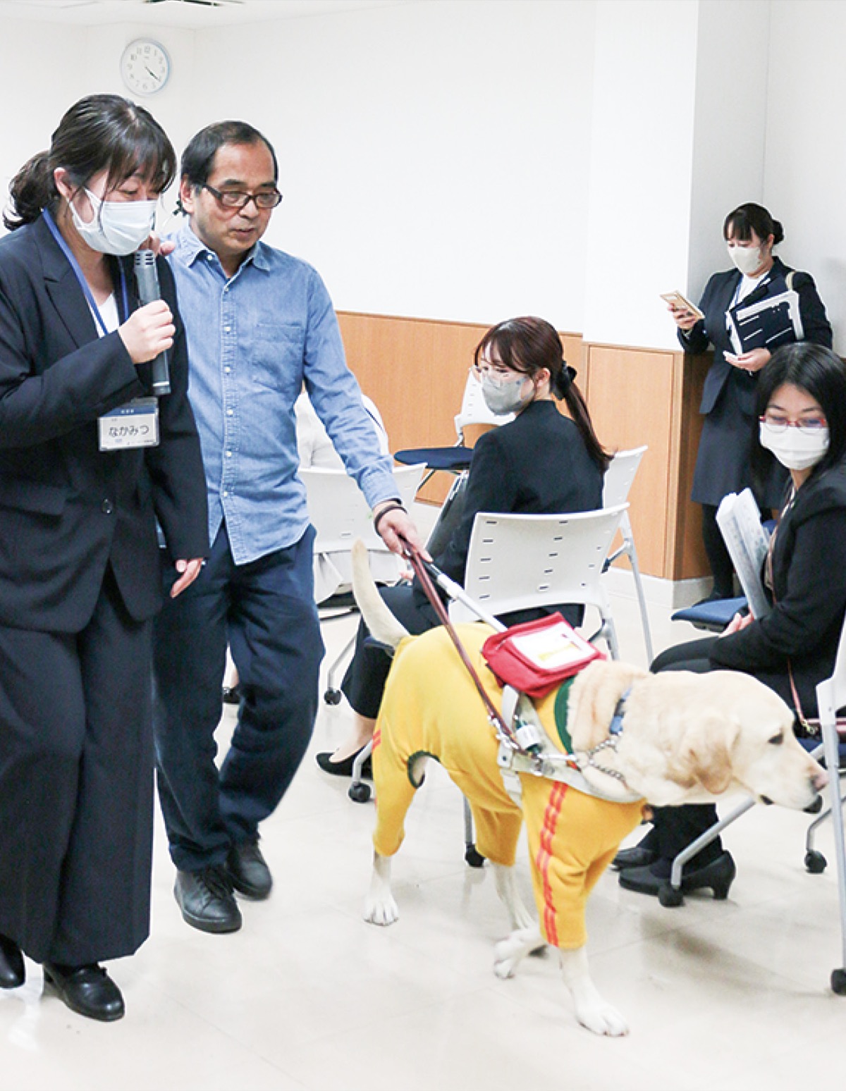 盲導犬ユーザーの介助をする参加者