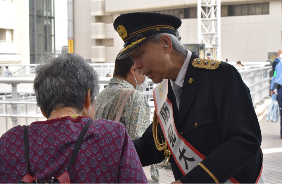 ガイドブックを配布する假屋崎さん
