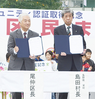 署名した協定書を披露する尾仲区長と島田村長