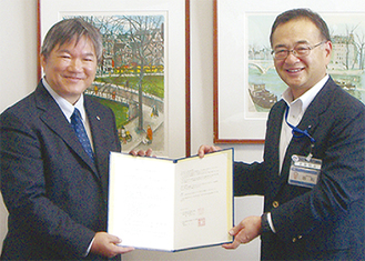 協定書を交わす岩倉会長（左）と坂和局長