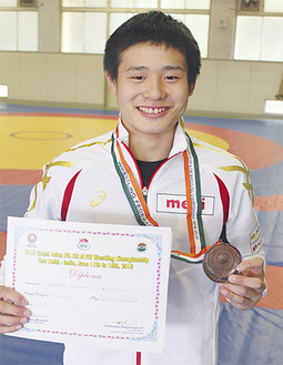 銅メダルと賞状を手に笑顔の林選手