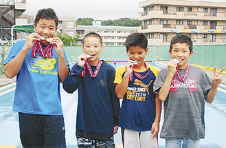 メダルを手に喜ぶ飯島さん、田橋さん、伊藤さん、杉山さん（左から）