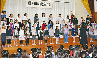 歌で祝福する合唱クラブの児童