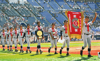 今大会から新調された優勝旗をスタンドに掲げながら行進する齊藤主将（右）ら横浜ナイン