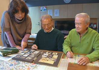 昔の写真を見ながら当時を振り返る水野さん（中央）と田中さん（右）。左は中村館長