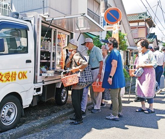 野島町内会館に来たユニクマ号で買い物をする住人ら