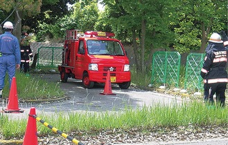 誘導を受け狭い道を走る消防車両（磯子消防署提供）