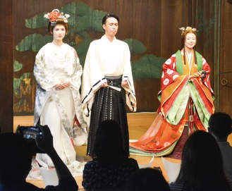 能舞台に立つ新婦・新郎役と十二単をまとったモデル（左から）