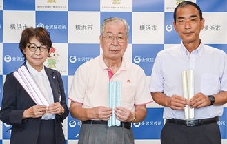 反射材を持つ長澤専務理事、横井会長、永井区長（右から）