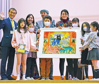寄贈された絵画を持つ各学年の代表児童ら
