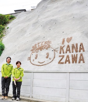 がけ地に描かれたぼたんちゃんと春峰園の加藤さん、大泉奈穂さん（左から）